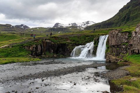 Hikers, tourists at Kirkjufellfoss waterfall, Kirkjufellsa river, Grundarfjördur, Snæfellsnes