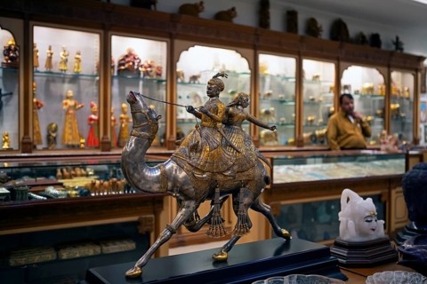 Prince and princess on a silver and gold foil camel in a shop in the old city centre, Jaipur,