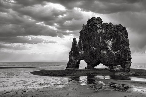 Basalt rock Hvitserkur, famous Elephant Rock on lava beach, coastline, dramatic cloudy sky, rain