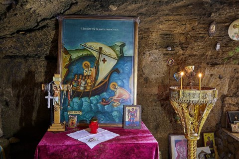 Altar with a painting of a biblical sea voyage, decorated with crosses and glowing candles, chapel,