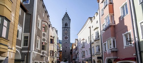 Old town, colourful houses in the main street, Zwölferturm tower at the back, old town, Sterzing,