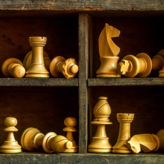 Wooden chess pieces arranged in a vintage box showcasing strategic game elements and craftsmanship