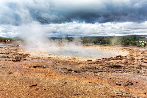 Steaming Strokkur, tourists waiting for eruption, high temperature area Haukadalur, tourist