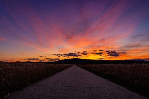 The sun has set behind the Taunus, a low mountain range in Hesse, and colours the evening sky,