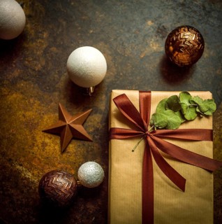 Close-up view of a beautifully wrapped gift parcel featuring a brown paper exterior and a rich