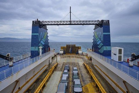 Ferry with parked cars and view of the sea under a cloudy sky, summer, Cook Strait, North Island,