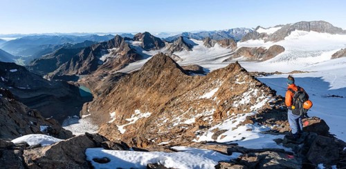 Mountaineer on a rocky ridge on the Wilder Freiger summit, behind him Signal summit and Becher