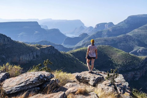 Tourist looking over canyon landscape, view of Blyde River gorge, Lowveld Viewpoint, in the evening