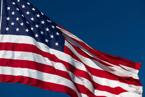 American flag waving in the wind against deep blue sky