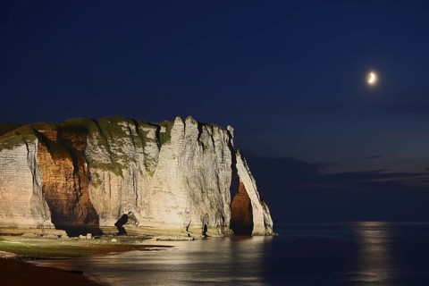 Cliffs with the Falaise d'Aval rock gate and the Aiguille rock needle at night, Etretat, Alabaster