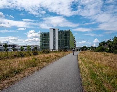 Cycle path on the banks of the Main with the multi-storey car park at the Edersheim lock in the