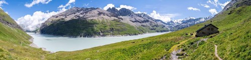 Panorama, blue mountain lake and alpine hut in mountain landscape, Lac des Dix reservoir and Mont