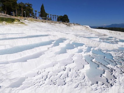 Cascading white terraces with turquoise water against a blue sky, aerial view, sinter terraces,