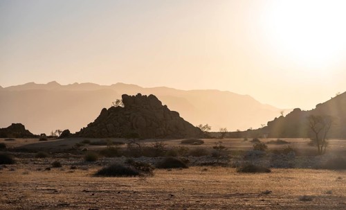 Desert landscape in the evening light at sunset, barren landscape with hills of stacked rocks,