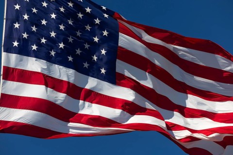 American flag waving in the wind against deep blue sky