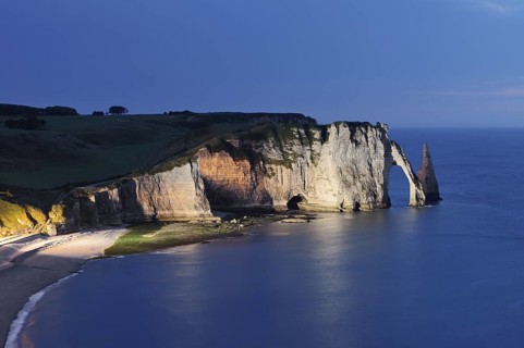 Cliffs with the Falaise d'Aval rock gate and the Aiguille d'Etretat rock needle at night, Etretat,