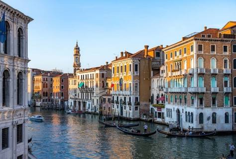 View of the Grand Canal with gondoliers at sunset, picturesque evening mood with palazzos on the