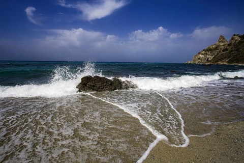 Dynamic wave movement on the beach with splashing spray and rocks, Ricadi, Capo Vaticano
