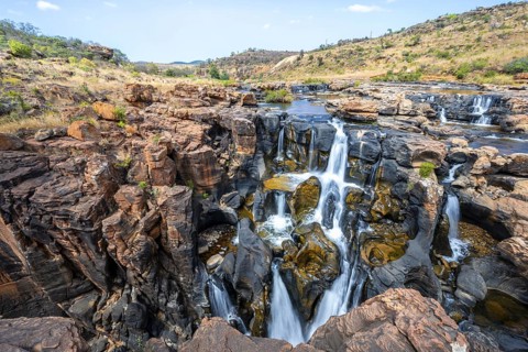 Waterfall on orange-coloured rock cliffs, long exposure, Blyde River, Bourke's Luck Potholes,