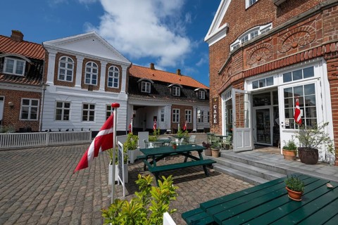 Cosy café with Danish flags and inviting terrace under a blue sky, Old Town, Ringkøbing, Ringkøbing