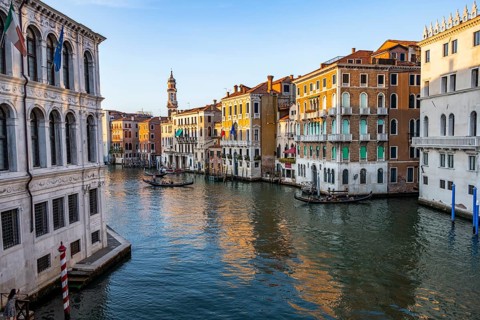 View of the Grand Canal with gondoliers at sunset, picturesque evening mood with palazzos on the