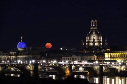 Glowing strawberry moon on 11 June 2025 over the Augustus Bridge in Dresden, between the