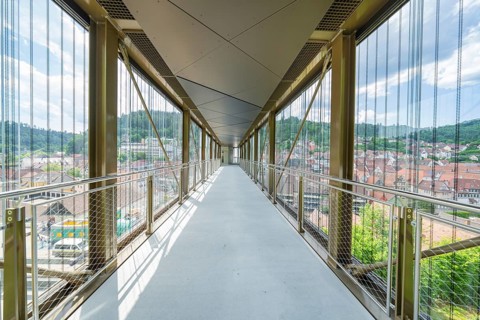 A modern, light-flooded glass corridor with a view of the urban surroundings, Zob extension with