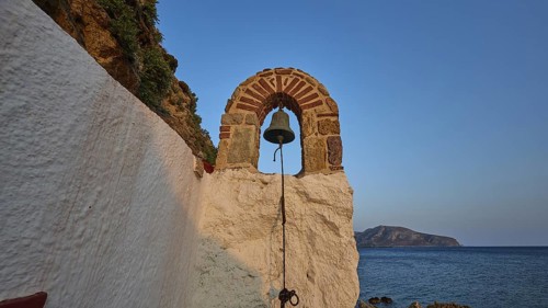 Legend, crab, shell fisherman, stone arch with bell overlooking the sea at sunset, surrounded by