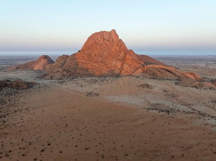 The isolated Spitzkoppe mountain (1728 m) majestically rises above the surrounding desert plains.