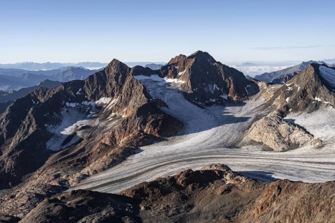 Picturesque high mountain landscape at sunrise, glacier and rocky mountain peaks in the morning