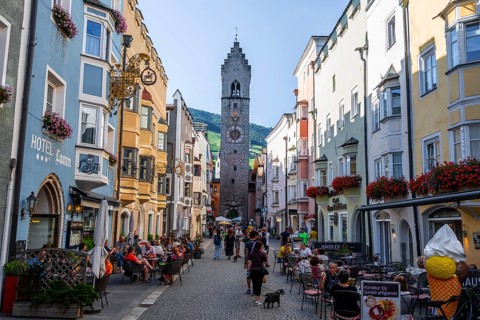 Old town, colourful houses in the main street, Zwölferturm tower at the back, old town, Sterzing,