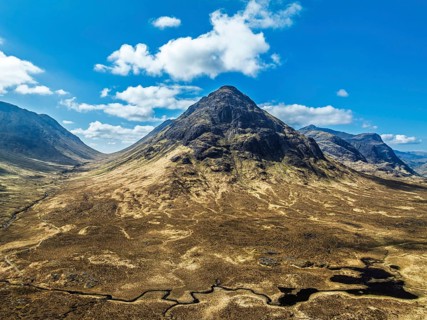 Buachaille Etive Beag and Three Sisters in Glencoe over Moors and Road A82 from a drone, Highlands,