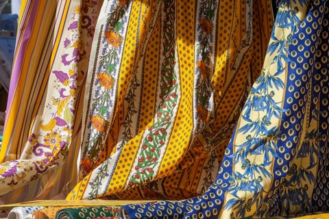Various decorative fabrics with floral patterns in yellow and blue, typical of Provence, France