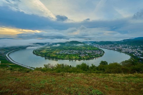 Panoramic view over river and valley, amidst hills in twilight and clouds, summer, Rhine bend