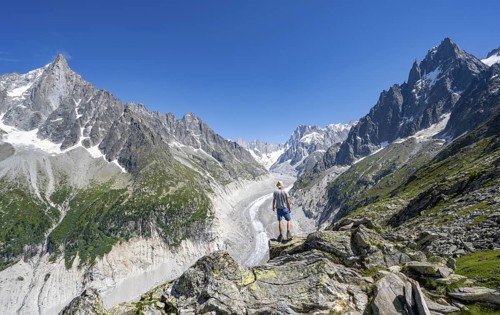 Picturesque mountain landscape with imposing mountain peaks and glaciers, mountaineer on hiking