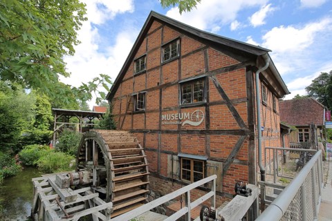 Grinding mill with brick building and water wheel, mill wheel, wooden construction, inscription,