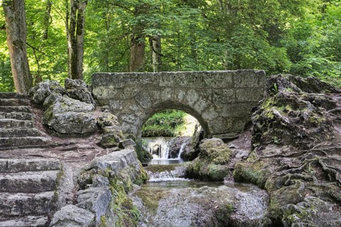 An old, small stone bridge over the Brühlbach, wild and romantic stream and source of the Urach