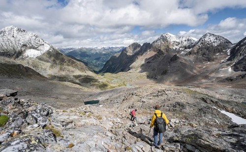 Two mountaineers in a rocky mountain landscape, descending from the summit of Keeskopf, behind them