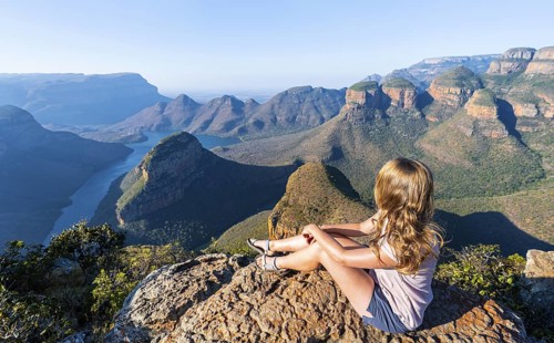 Hiker enjoying sunset at Blyde River Canyon with Three Rondawels peak, view of canyon with Blyde