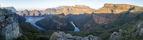 Hiker enjoying panorama, sunset at Blyde River Canyon with Three Rondawels peak, view of canyon