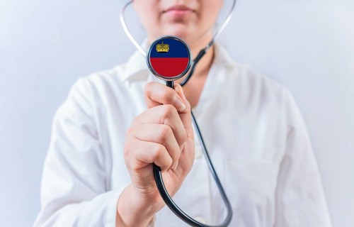 Female doctor holding stethoscope with Liechtenstein flag. National health system of Liechtenstein