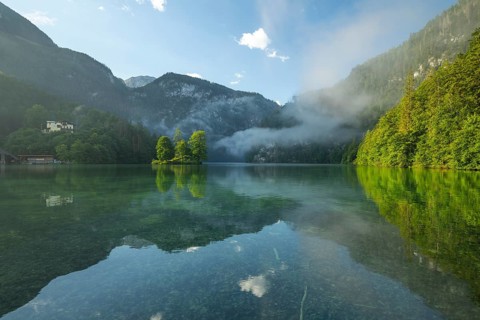 Mystical morning at Königssee in Schönau with boathouses and Christlieger. Sunrise and beautiful