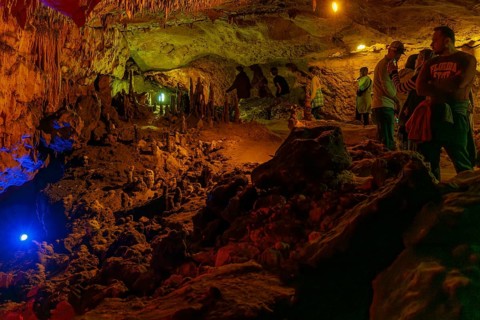 Tourists walking past limestone rock formations in a cave at Florida Caverns State Park in the