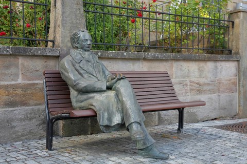 Johann Wolfgang von Goethe by Klaus Gutting sitting on the bench, bronze sculpture, looking, arms,