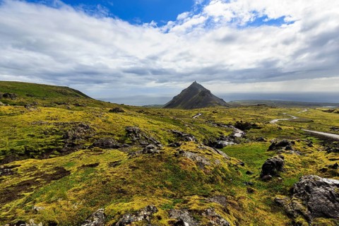 Barren moss-covered volcanic landscape, cone-shaped mountain Stapafell, rain clouds, changeable