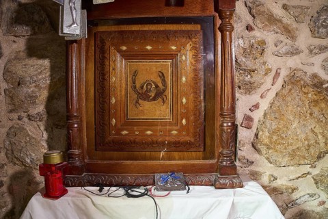 Legend, crab, shell fisherman, wood carving with crab motif in a chapel on an altar with candle,