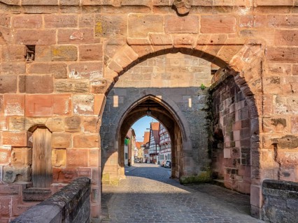 Alley with cobblestones leads through the town gate Oberes Tor, view through the gate to the
