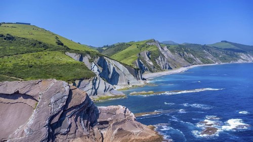 Breathtaking aerial view of the iconic zumaia flysch cliffs meeting the vibrant turquoise waters of
