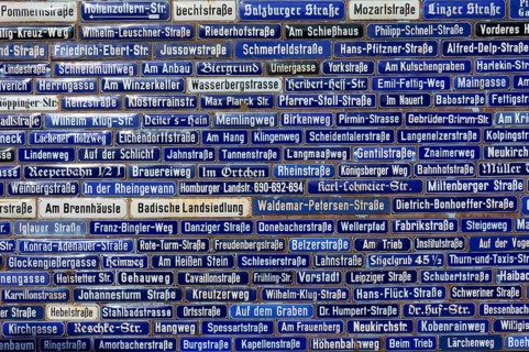 Wall with many blue street signs showing different names, Amorbach, Odenwald, Bavaria, Germany