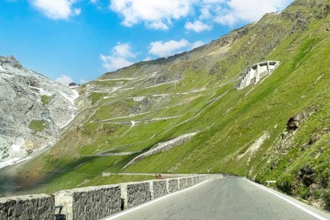View of east ramp ascent to descent from Alpine pass Stelvio Stilfserjoch mountain road above tree